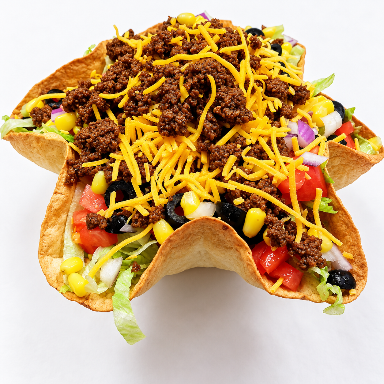 Crispy tortilla bowl taco salad with seasoned beef, shredded cheese, corn, black olives and tomatoes